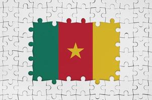 Cameroon flag in frame of white puzzle pieces with missing central part photo