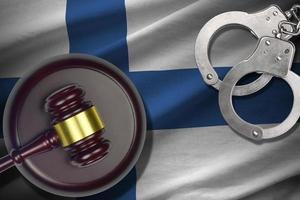 Finland flag with judge mallet and handcuffs in dark room. Concept of criminal and punishment, background for judgement topics photo