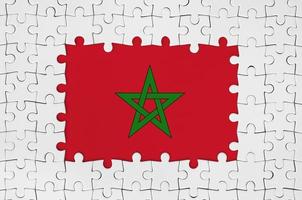 bandera de marruecos en el marco de piezas de un rompecabezas blanco con la parte central faltante foto