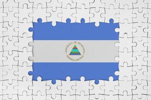 bandera de nicaragua en el marco de piezas de un rompecabezas blanco con la parte central faltante foto