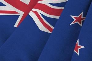 bandera de nueva zelanda con grandes pliegues ondeando de cerca bajo la luz del estudio en el interior. los símbolos y colores oficiales en banner foto