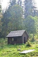 pequeña casa natural, que está construida de madera. el edificio está ubicado en el bosque foto