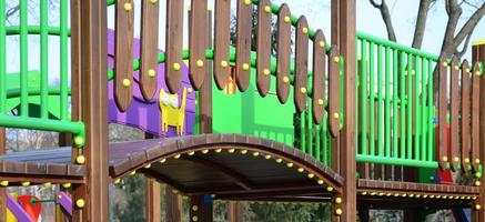 Fragment of a playground made of plastic and wood, painted in different colors photo