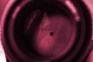 Fragment of a portrait lens for a modern SLR camera. A photograph of a wide-aperture lens with a focal length of 50mm Image toned in Viva Magenta, color of the year photo