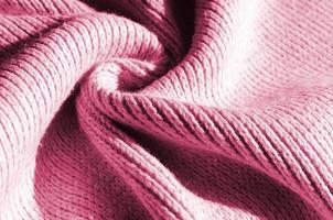 Fabric texture of a soft yellow knitted sweater. Macro image of the structure of bindings in yarns Image toned in Viva Magenta, color of the year photo