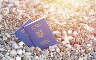 Two biometrical ukrainian passports on sea shore background photo