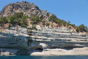 paisaje de las montañas de roca natural de turquía sobre el agua azul del mar foto