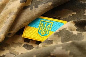 Military camouflage fabric with ukrainian flag on uniform chevron photo