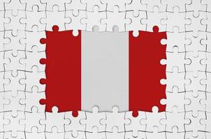 bandera peruana en el marco de piezas de un rompecabezas blanco con la parte central faltante foto