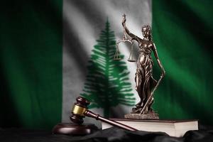 Norfolk island flag with statue of lady justice, constitution and judge hammer on black drapery. Concept of judgement and guilt photo