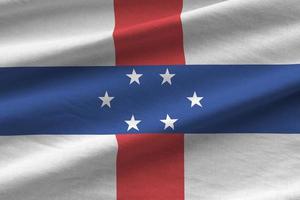 Netherlands Antilles flag with big folds waving close up under the studio light indoors. The official symbols and colors in banner photo