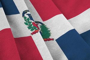 Dominican Republic flag with big folds waving close up under the studio light indoors. The official symbols and colors in banner photo