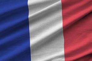 France flag with big folds waving close up under the studio light indoors. The official symbols and colors in banner photo