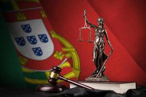 bandera de portugal con estatua de la dama de la justicia, constitución y martillo de juez sobre cortinas negras. concepto de juicio y culpa foto