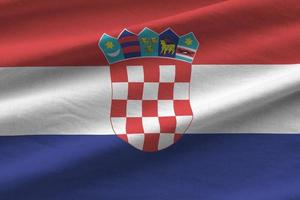 Croatia flag with big folds waving close up under the studio light indoors. The official symbols and colors in banner photo