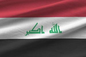 Iraq flag with big folds waving close up under the studio light indoors. The official symbols and colors in banner photo