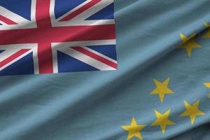 Tuvalu flag with big folds waving close up under the studio light indoors. The official symbols and colors in banner photo