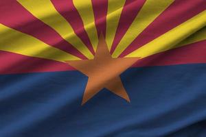 Arizona US state flag with big folds waving close up under the studio light indoors. The official symbols and colors in banner photo