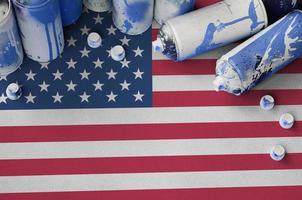 United States of America flag and few used aerosol spray cans for graffiti painting. Street art culture concept photo