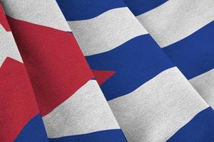Cuba flag with big folds waving close up under the studio light indoors. The official symbols and colors in banner photo