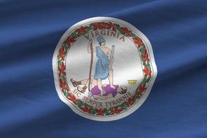 Virginia US state flag with big folds waving close up under the studio light indoors. The official symbols and colors in banner photo
