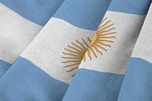 Argentina flag with big folds waving close up under the studio light indoors. The official symbols and colors in banner photo