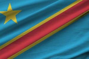 Democratic Republic of the Congo flag with big folds waving close up under the studio light indoors. The official symbols and colors in banner photo