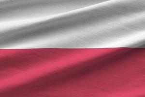 Poland flag with big folds waving close up under the studio light indoors. The official symbols and colors in banner photo