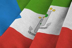 Equatorial Guinea flag with big folds waving close up under the studio light indoors. The official symbols and colors in banner photo