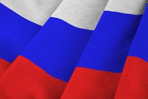 Russia flag with big folds waving close up under the studio light indoors. The official symbols and colors in banner photo