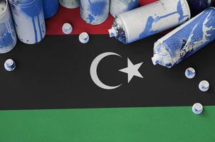 Libya flag and few used aerosol spray cans for graffiti painting. Street art culture concept photo