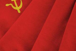 Soviet Union flag with big folds waving close up under the studio light indoors. The official symbols and colors in banner photo