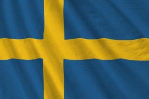 Sweden flag with big folds waving close up under the studio light indoors. The official symbols and colors in banner photo