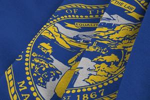 Nebraska US state flag with big folds waving close up under the studio light indoors. The official symbols and colors in banner photo