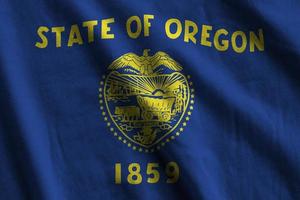 Oregon US state flag with big folds waving close up under the studio light indoors. The official symbols and colors in banner photo