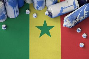 Senegal flag and few used aerosol spray cans for graffiti painting. Street art culture concept photo