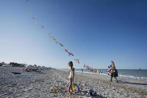 Baby girl look ar kite seller in beach Porto Sant Elpidio, Italy. photo