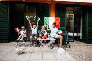 felices cuatro niños con banderas italianas celebrando el día de la república de italia. foto