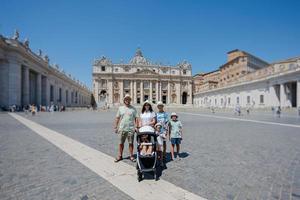 Large family stand against St. Peter's Basilica church in Vatican city. photo