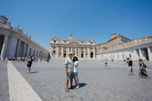 pareja de pie contra st. iglesia basílica de san pedro en ciudad del vaticano. foto