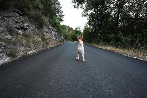 niña corre en la carretera de montaña de nocera umbra, ciudad y comuna en la provincia de perugia, italia. foto