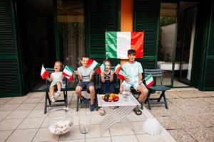felices cuatro niños con banderas italianas celebrando el día de la república de italia. foto