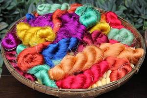 viajar a bangkok, tailandia. hilos coloridos de seda tailandesa en un primer plano de cesta para el fondo. foto