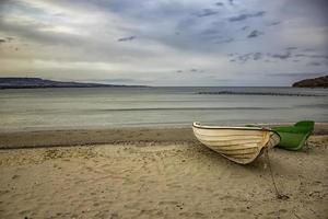 Fishing boats at the end of a day on sea beach background with copy space photo