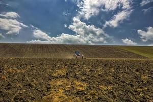 vista de día de un tractor trata el suelo en una colina de montaña foto