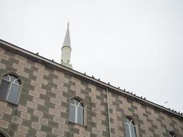 Mosque wall with doves. The birds are sitting on the wall. Minaret photo