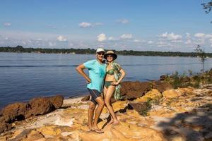 Mature Couple Standing on the rocky shore line of the Rio Negro River in Novo Airao, Brazil photo