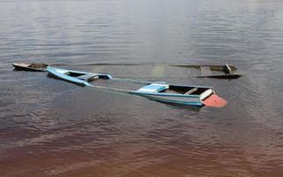 Small old wooden boats filled with water found on the shore of the Rio Negro River in Airao, Brazil photo