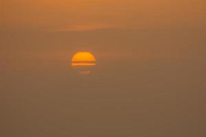 half covered sun during sunrise at the sea in egypt detail photo