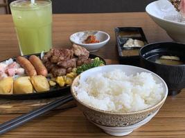 Various menus, sushi, sashimi, nigiri, pan fried pork and miso soup. Sashimi, chutoro sashimi, Japanese food chopsticks and wasabi on the black table, Japanese food style. blurs focus. photo